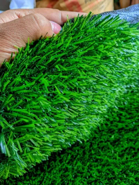 Fibres denses du gazon synthétique tenues à la main